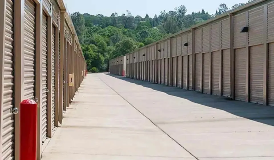 Outdoor self-storage units with secure roll-up doors and wide access driveway